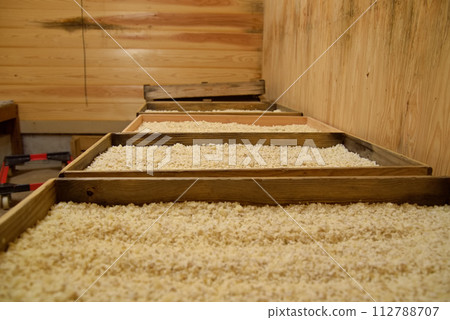 Wooden boxes and rice malt lined up inside the storehouse Wooden boxes and rice malt lined up inside the storehouse 112788707