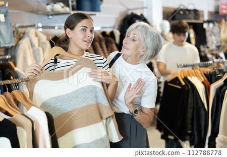 Ladies carefully select sweaters 112788778