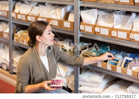 Woman chooses a glaze based on samples for future earthenware or ceramic dishes 112788817