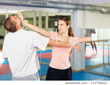 Young woman practicing palm heel strike in chin in self-defense training 112788822