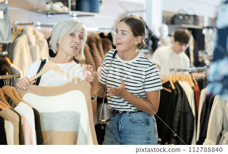 Ladies carefully select sweaters 112788840
