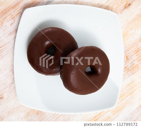 Two chocolate glazed donuts 112789172