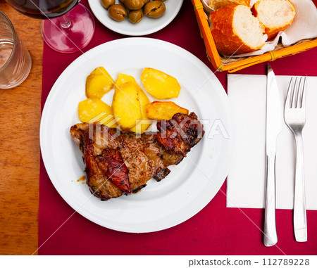 Honey glazed beef ribs with potato on table Honey glazed beef ribs with potato on table 112789228