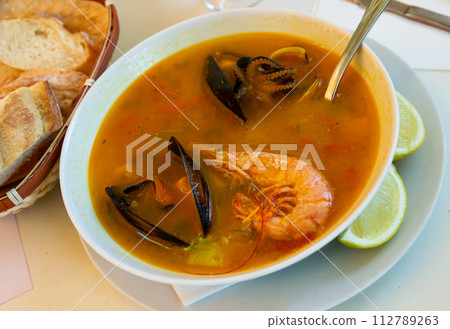 Hot seafood soup with prawns, mussels and vegetables served Hot seafood soup with prawns, mussels and vegetables served 112789263