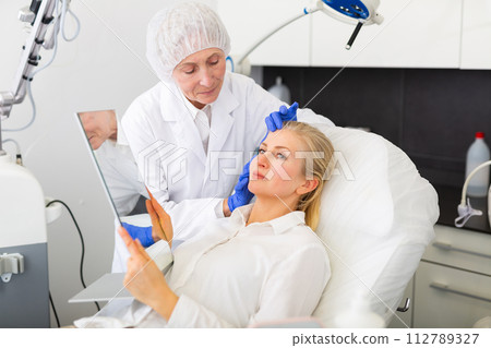 Experienced female cosmetologist consulting woman before facial treatments 112789327