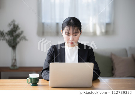 Japanese business woman operating a computer, front view Japanese business woman operating a computer, front view 112789353