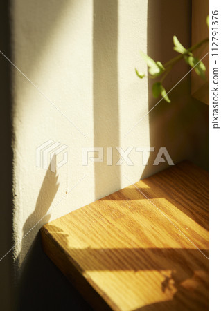Comfortable rest by the sunny window. A background with sunlight and shadows that can be used in various designs. 112791376