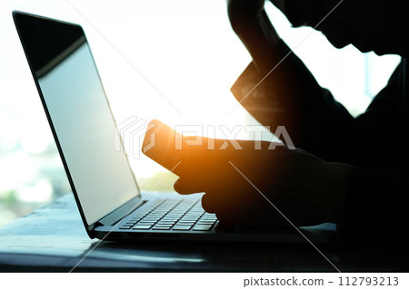 man sitting down, his face unsettled. At the computer desk she has headaches and stress. Cause of hard work and insufficient rest. 112793213