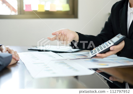 Two business leaders talk about charts, financial graphs showing results are analyzing and calculating planning strategies, business success building processes 112797952