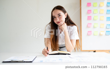 Asian businesswoman calculate financial graphs showing results about their investments, planning a successful business growth process in the office Asian businesswoman calculate financial graphs showing results about their investments, planning a successful business growth process in the office 112798165