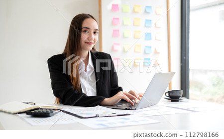 Asian businesswoman calculate financial graphs showing results about their investments, planning a successful business growth process in the office Asian businesswoman calculate financial graphs showing results about their investments, planning a successful business growth process in the office 112798166