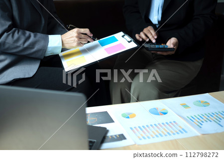 Two business leaders talk about charts, financial graphs showing results are analyzing and calculating planning strategies, business success building processes 112798272