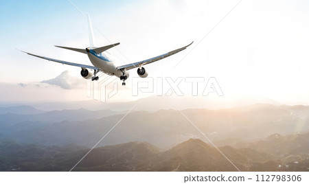 Passengers commercial airplane flying above mountains Passengers commercial airplane flying above mountains 112798306