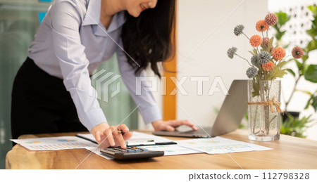 Asian businesswoman calculate financial graphs showing results about their investments and plan successful business growth process 112798328