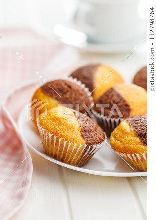 Close Up of a Muffina on plate on a white Table Close Up of a Muffina on plate on a white Table 112798764
