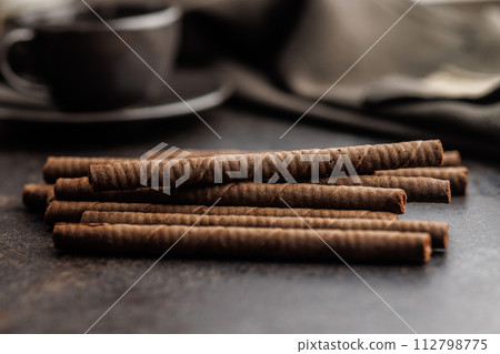 Chocolate Wafer Rolls on dark table. Chocolate Wafer Rolls on dark table. 112798775