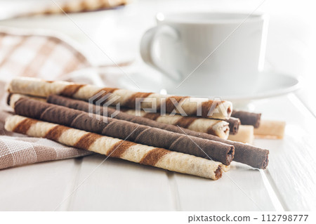 Assorted Chocolate and Vanilla Cream Filled Wafer rolls on white table. Assorted Chocolate and Vanilla Cream Filled Wafer rolls on white table. 112798777