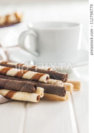 Assorted Chocolate and Vanilla Cream Filled Wafer rolls on white table. Assorted Chocolate and Vanilla Cream Filled Wafer rolls on white table. 112798779