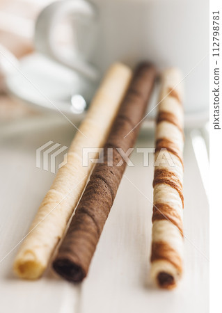 Assorted Chocolate and Vanilla Cream Filled Wafer rolls on white table. Assorted Chocolate and Vanilla Cream Filled Wafer rolls on white table. 112798781