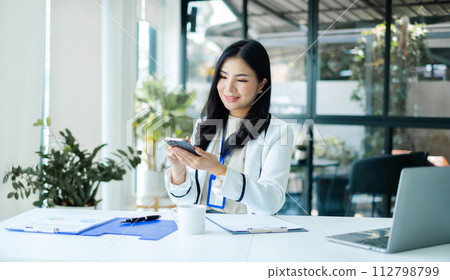 Asian businesswoman sit at their desks and calculate financial graphs showing results about their investments, planning a successful business growth process 112798799