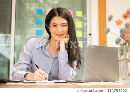 Asian businesswoman sit at their desks and calculate financial graphs showing results about their investments, planning a successful business growth process 112798802