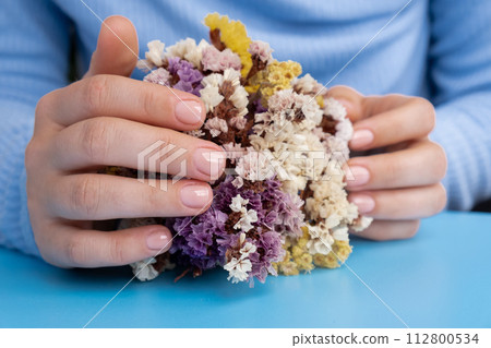 Stylish nude beige female nails on blue background. Modern trendy stylish Beautiful manicure. Cute pastel nail minimalistic design concept of beauty treatment. Gel nails. Skin care 112800534