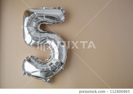 5 five metallic balloon on beige neutral background. Greeting card silver foil balloon number Happy birthday holiday concept. Copy space for text. Celebration party congratulation 5 five metallic balloon on beige neutral background. Greeting card silver foil balloon number Happy birthday holiday concept. Copy space for text. Celebration party congratulation 112800865
