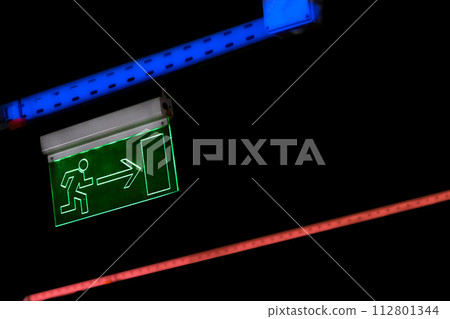 Glowing sign of entrance, exit, directions with the image of a man in the dark 112801344