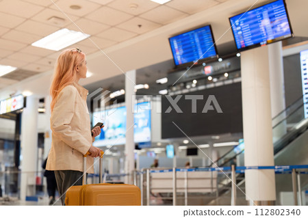 Digital monitor in an airport to check the gate and time to board the plane to travel work abroad Digital monitor in an airport to check the gate and time to board the plane to travel work abroad 112802340