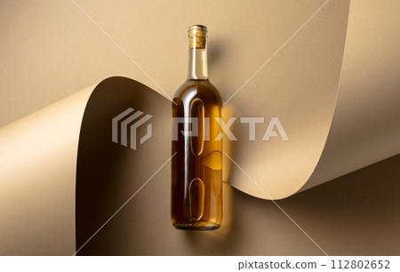Bottle of white wine on a beige background. 112802652