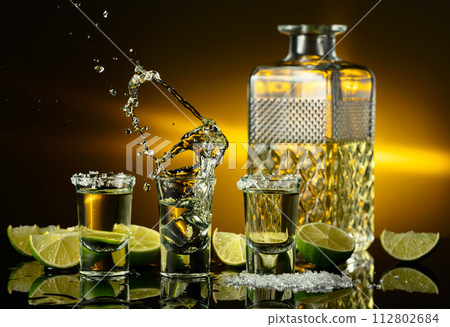 Gold tequila with sea salt and lime slices. Gold tequila with sea salt and lime slices. 112802684