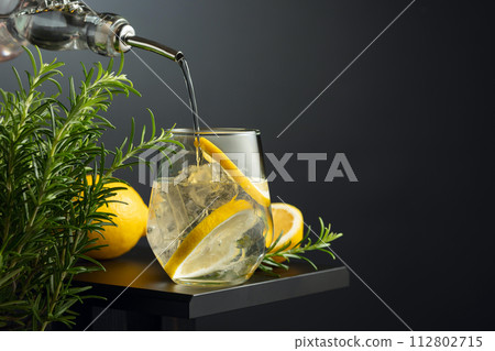 Cocktail gin tonic with ice, lemon, and rosemary. 112802715