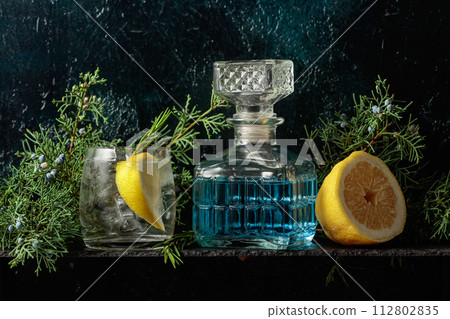 Cocktail gin-tonic with ice, lemon, and rosemary in a frozen glass. 112802835