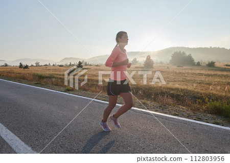 Determined Dawn: Confident and Motivated Athlete Embarks on Sunrise Run. Determined Dawn: Confident and Motivated Athlete Embarks on Sunrise Run. 112803956