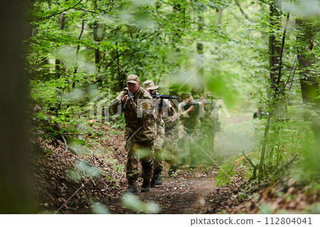 A disciplined and specialized military unit, donned in camouflage, strategically patrolling and maintaining control in a high-stakes environment, showcasing their precision, unity, and readiness for A disciplined and specialized military unit, donned in camouflage, strategically patrolling and maintaining control in a high-stakes environment, showcasing their precision, unity, and readiness for 112804041