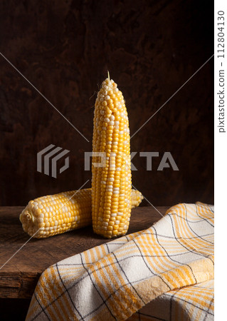 Two cobs sweet corn on wooden background.. Two cobs sweet corn on wooden background.. 112804130