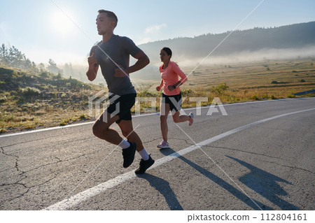 Energized by the beauty of nature, a couple powers through their morning run, their bodies and spirits invigorated. 112804161