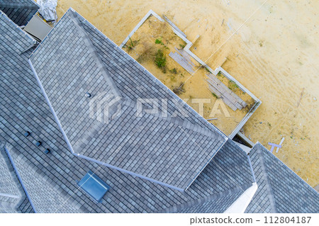 Rooftop of newly constructed house covered in asphalt shingles 112804187
