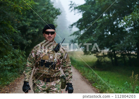 Elite soldier exudes focused determination and readiness, geared up for a perilous military operation, capturing the essence of courage and professionalism in the face of imminent danger Elite soldier exudes focused determination and readiness, geared up for a perilous military operation, capturing the essence of courage and professionalism in the face of imminent danger 112804203