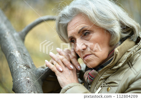 Portrait of senior sad woman in park Portrait of senior sad woman in park 112804209
