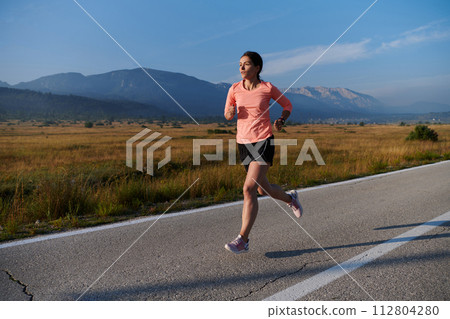 Determined Dawn: Confident and Motivated Athlete Embarks on Sunrise Run. 112804280