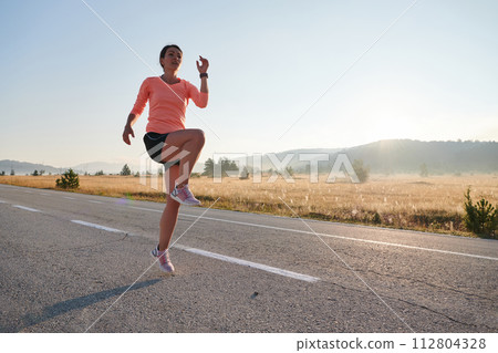 Determined Stretch: Athletic Woman Embraces Post-Run Flexibility in Nature. 112804328