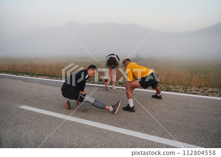 Diverse Athletes Prepare: Dynamic Group Warms Up for Morning Run. Diverse Athletes Prepare: Dynamic Group Warms Up for Morning Run. 112804558