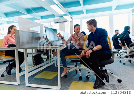 Collaborative process of multicultural skilled young business team during brainstorming meeting in office.Diverse group of young people dressed in formal wear cooperating on developing design project 112804818