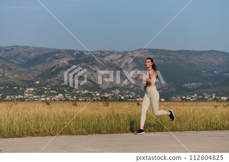 A determined woman athlete trains for success in the morning sun. 112804825