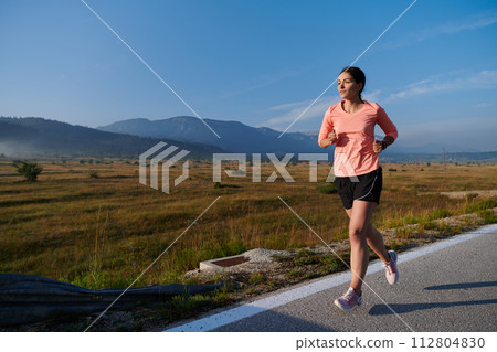 Determined Dawn: Confident and Motivated Athlete Embarks on Sunrise Run. 112804830