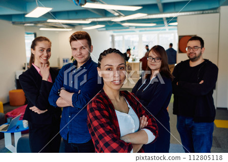 Portrait of a successful creative businessman and businesswoman looking at camera and smiling. Diverse business people standing together at startup. 112805118