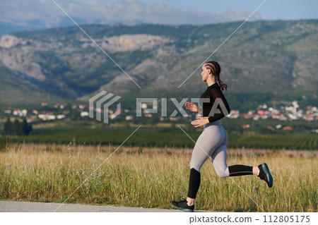 Solo Stride: Determined Athlete Woman Embarks on Fitness Journey for Marathon Preparation. Solo Stride: Determined Athlete Woman Embarks on Fitness Journey for Marathon Preparation. 112805175