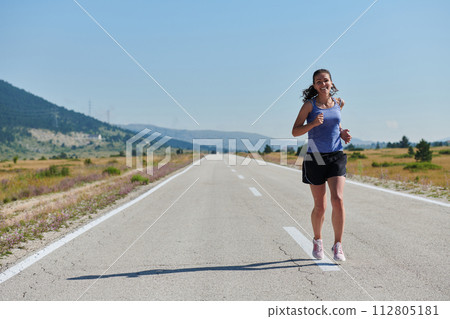 A determined woman athlete trains for success in the morning sun. 112805181