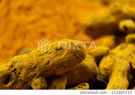 Dried turmeric root and turmeric powder close-up macro. Dried turmeric root and turmeric powder close-up macro. 112805319